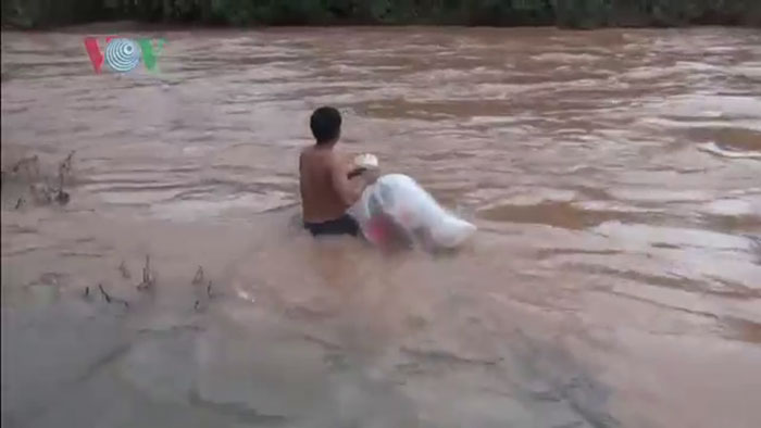 vietnamese schoolkids in plastic bags crossing river